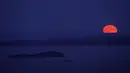 Supermoon terbit di belakang Isle Au Haut di kejauhan, dan Pulau North Haven, bagian tengah, Selasa, 1 Agustus 2023, seperti yang terlihat dari Camden, Maine. Fenomena supermoon 1 Agustus 2023 ini merupakan supermoon kedua dari empat supermoon yang terjadi pada musim panas tahun ini. (AP Photo/Robert F. Bukaty)