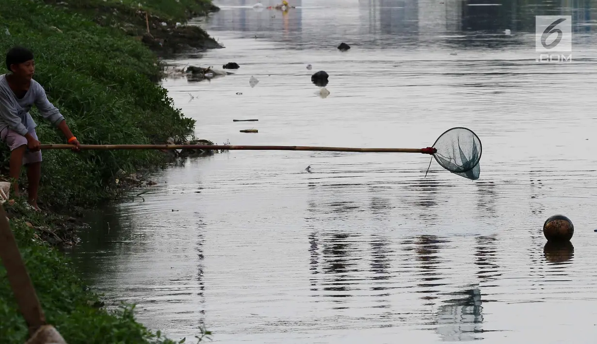 Seorang anak mengambil bola di kali saat kompetisi sepak bola di pinggir Kali Banjir Kanal Barat, Jakarta, Sabtu (5/11). Minimnya sarana bermain sepak bola mengakibatkan warga terpaksa memanfaatkan lahan di pinggir kali. (Liputan6.com/Johan Tallo)