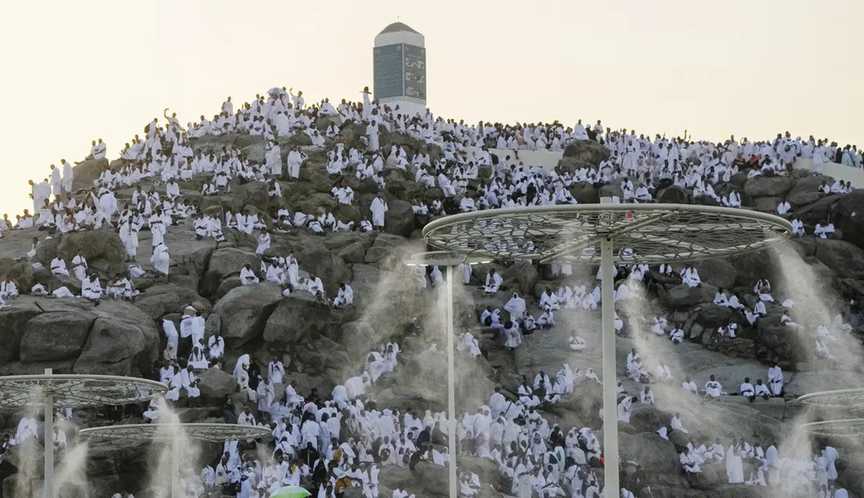 Kabut air disemprotkan ke jemaah haji saat mereka berdoa di bukit berbatu yang dikenal sebagai Gunung Rahmat di Dataran Arafah selama ibadah haji tahunan dekat Kota Suci Makkah, Arab Saudi, Selasa (27/6/2023). Sekitar dua juta jemaah berkumpul di Kota Suci Makkah untuk haji terbesar sejak pandemi virus corona COVID-19 yang sangat membatasi akses ke salah satu dari lima rukun Islam tersebut. (AP Photo/Amr Nabil)