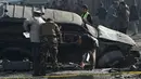 Anggota keamanan Afghanistan memeriksa sebuah mobil yang rusak di jalanan Ibu Kota Afghanistan, Kabul, Rabu (28/12). Sebuah ledakan bom mengguncang kendaraan anggota parlemen dan menyebabkan tiga orang mengalami luka-luka. (WAKIL KOHSAR/AFP)