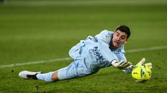 Kiper Real Madrid, Thibaut Courtois, berusaha menangkap bola saat melawan Elche pada laga Liga Spanyol di Stadion Manuel Martinez Valero, Rabu (30/12/2020). Kedua tim bermain imbang 1-1. (AP/Jose Breton)