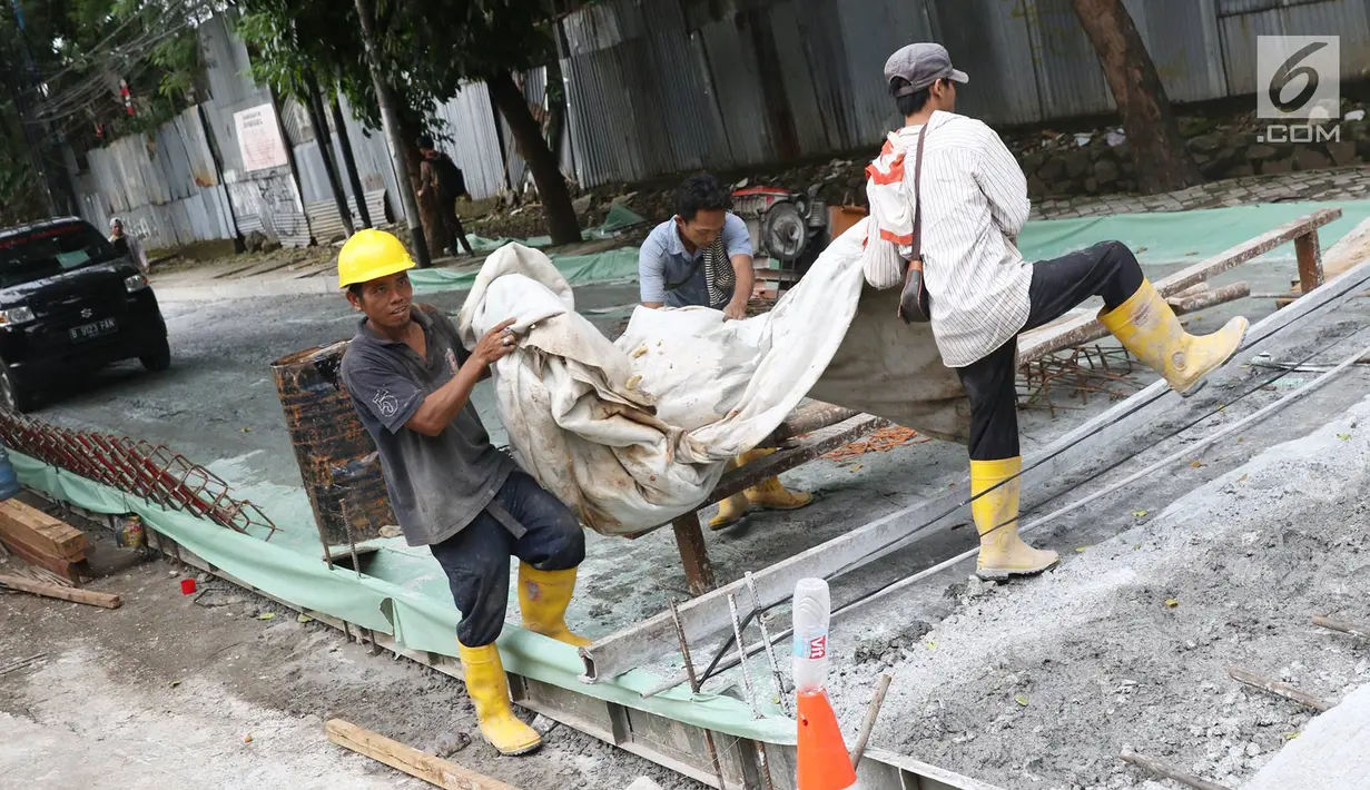 Pekerja menyelesaikan pembetonan Jalan Pejaten Raya di Jakarta Selatan (22/11). Proyek pembetonan dan peninggian badan jalan ini ditargetkan rampung pada akhir November. (Liputan6.com/Immanuel Antonius)