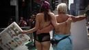 Dua orang wanita saat berpartisipasi dalam parade GoTopless di Manhattan, New York City, Minggu (23/8/2015). Aksi tersebut menuntut persamaan hak untuk bertelanjang dada seperti pria. (Kena Betancur/Getty Images/AFP)