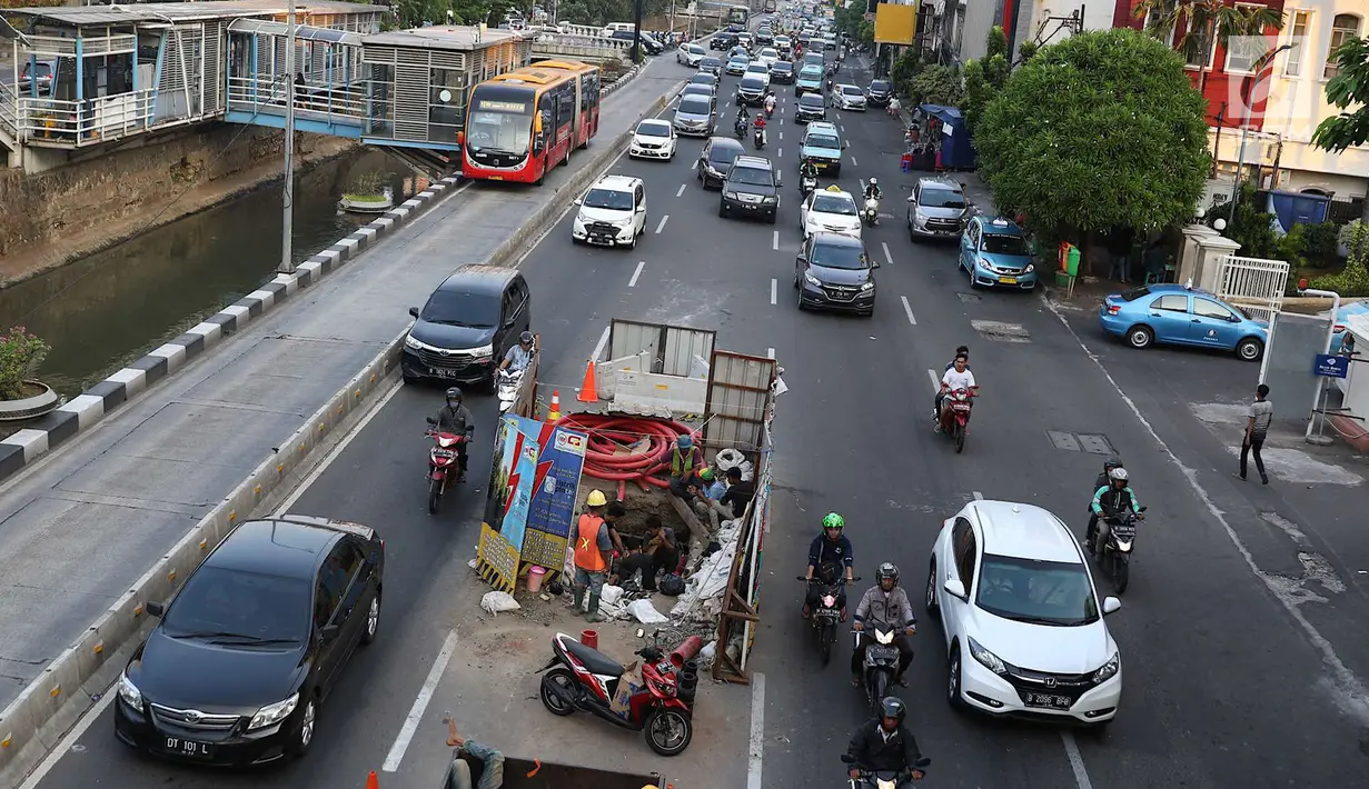 Kendaraan melintas di samping pengerjaan galian kabel bawah tanah di tengah Jalan Gajah Mada, Jakarta, Senin (11/6). Proyek yang dicanangkan Mei 2015 tersebut merupakan bagian dari proyek pembangkit listrik 35.000 MW. (Liputan6.com/Immanuel Antonius)