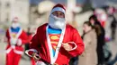 Seorang pria berpakaian Santa Claus dengan kaos Superman ikut serta dalam perlombaan lari tradisional Santa Claus Tahun Baru di Skopje, (24/12) (AFP Photo / Robert Atanasovki)
