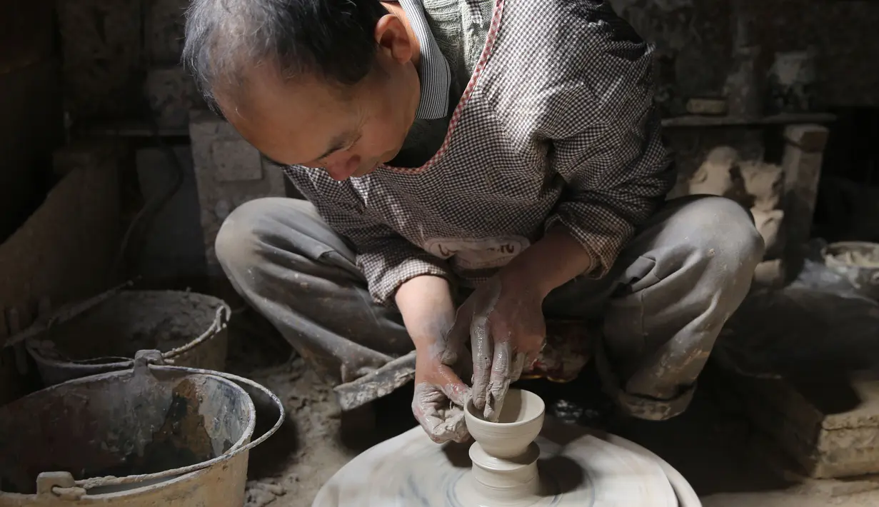 Seorang perajin bekerja di bengkel pembuatan tembikar di Desa Wanyao, Mazhan, Tengchong, Provinsi Yunnan, China, 18 November 2020. Produk tembikar dari desa ini memiliki bentuk yang sederhana namun praktis. (Xinhua/Liang Zhiqiang)