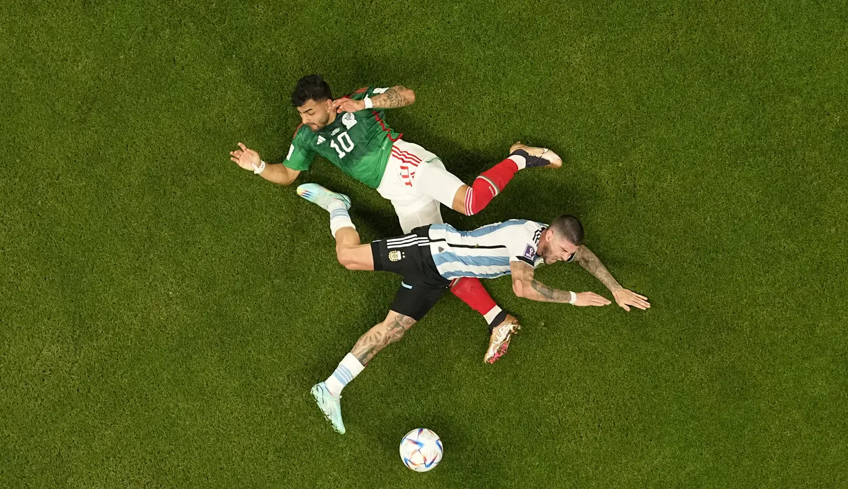 Gelandang Argentina, Rodrigo De Paul berebut bola dengan Penyerang Meksiko,  Alexis Vega selama pertandingan grup C Piala Dunia 2022 Qatar di Stadion Lusail di Lusail, Qatar, Minggu 27 November 2022. Dengan kemenangan atas Meksiko ini, Lionel Messi cs masih berpeluang besar untuk bisa lolos ke babak 16 besar Piala Dunia 2022. (AP Photo/Pavel Golovkin)