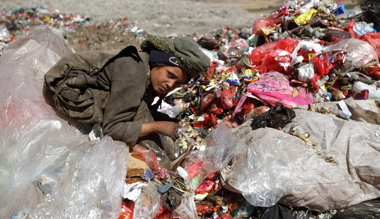 Seorang bocah laki-laki duduk di antara tumpukan sampah di sebuah tempat pembuangan akhir (TPA) di pinggiran Sanaa, Yaman, Rabu (16/11). Setiap hari para bocah di daerah tersebut mengumpulkan sampah untuk didaur ulang. (REUTERS/Mohamed al-Sayaghi)
