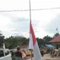 Bendera Merah Putih setengah tiang berkibar di rumah-rumah warga, menyambut kedatangan jenazah almarhum Letnan Satu Anumerta Marinir Muhammad Iqbal, di Desa Anggotoa, Kecamatan Wawotobi, Kabupaten Konawe, Provinsi Sulawesi Tenggara. (Liputan6.com/ Ist