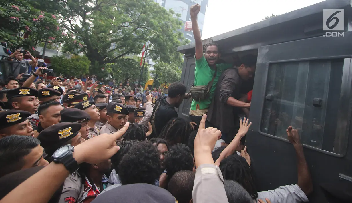 Sejumlah massa dari FRI-WP dan AMP dimasukan ke dalam mobil tahanan saat diamankan petugas polisi di Jalan Medan Merdeka Barat, Jakarta, Selasa (15/8). (Liputan6.com/Immanuel Antonius)