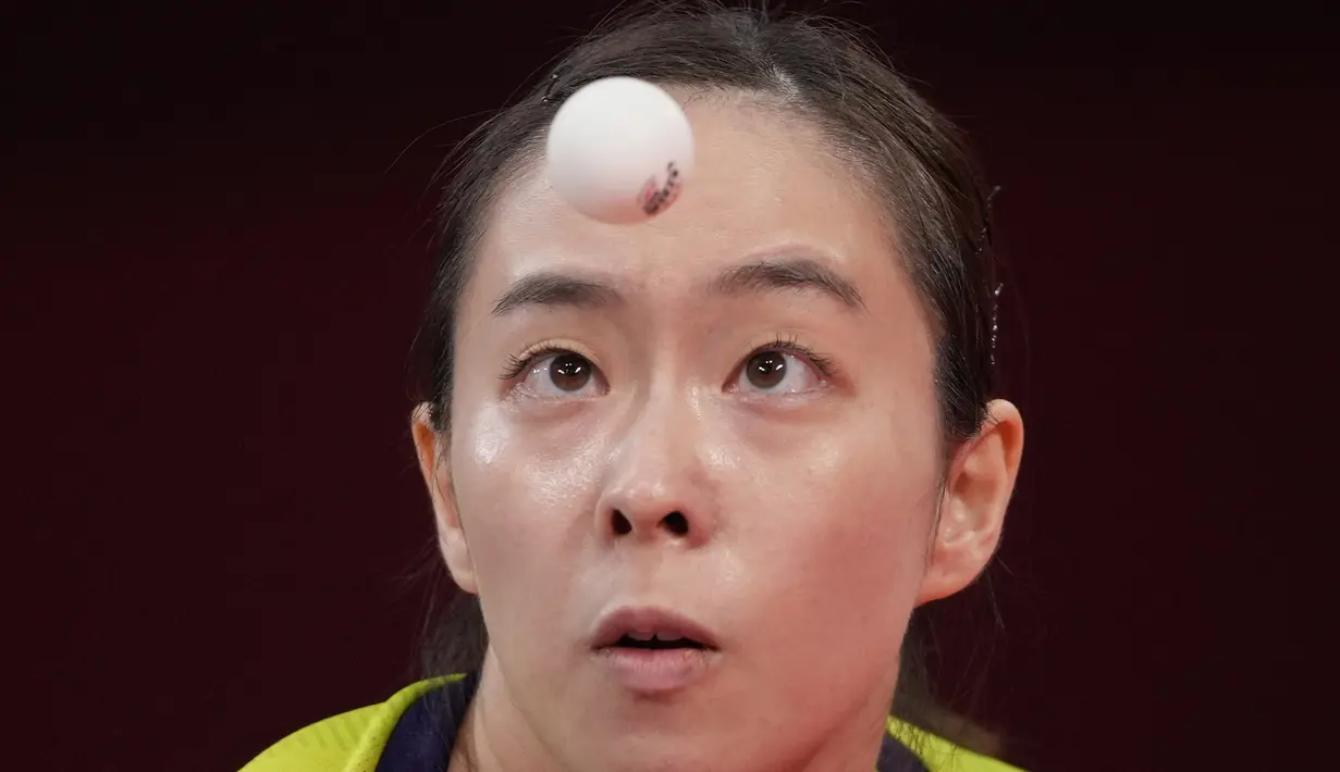 Atlet Jepang Kasumi Ishikawa melakukan servis saat bertanding melawan Lam Sofia Polcanova dari Austria dalam pertandingan babak 16 besar tenis meja tunggal putri di Olimpiade Musim Panas 2020 di Tokyo, Selasa (27/7/2021). (AP Photo/Kin Cheung)