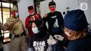 Petugas kepolisian berpakaian pejuang jaman dulu saat memberikan semangat kepada warga yang sedang divaksin Covid-19 di Polsek Pasar Rebo, Jakarta, Selasa (17/8/2021). Para petugas berkostum pejuang jaman dulu memeriahkan HUT ke-76 Republik Indonesia. (Liputan6.com/Angga Yuniar)
