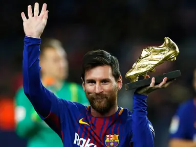 Pemain bintang Barcelona, Lionel Messi memamerkan Sepatu Emas Eropa sebelum melawan Deportivo La Coruna dalam pertandingan liga Spanyol di stadion Camp Nou di Barcelona (17/12). (AP Photo/Manu Fernandez)