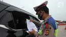 Polisi memeriksa kendaraan di Gerbang Tol Palimanan, Jakarta, Jumat, (7/5/2021). Gerbang Tol Palimanan terpantau sepi pemudik dan didominasi oleh kendaraan angkutan barang pada hari kedua penyekatan. (merdeka.com/Imam Buhori)