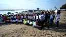 Massa mengangkat plakat saat kampanye perubahan iklim global di Pantai Sanur, Bali, Jumat (20/9/2019). Massa mendukung untuk pengurangan kenaikan suhu yang cukup signifikan. (SONNY TUMBELAKA/AFP)