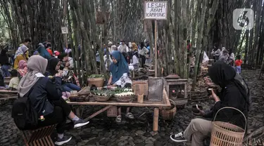 Wisatawan menyantap makanan saat berkunjung ke Pasar Papringan, Ngadiprono, Kabupaten Temanggung, Jawa Tengah, Minggu (26/2/2023). Pasar Papringan Ngadiprono menjadi salah satu destinasi wisata unik di Kabupaten Temanggung. (merdeka.com/Iqbal S. Nugroho)