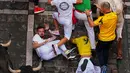 Para pengunjung berlari dan terjatuh di samping banteng-banteng petarung Victoriano del Río selama acara lari banteng ketiga di festival San Fermín di Pamplona, Spanyol, Kamis, 9 Juli 2026. (AP Photo/Miguel Oses)