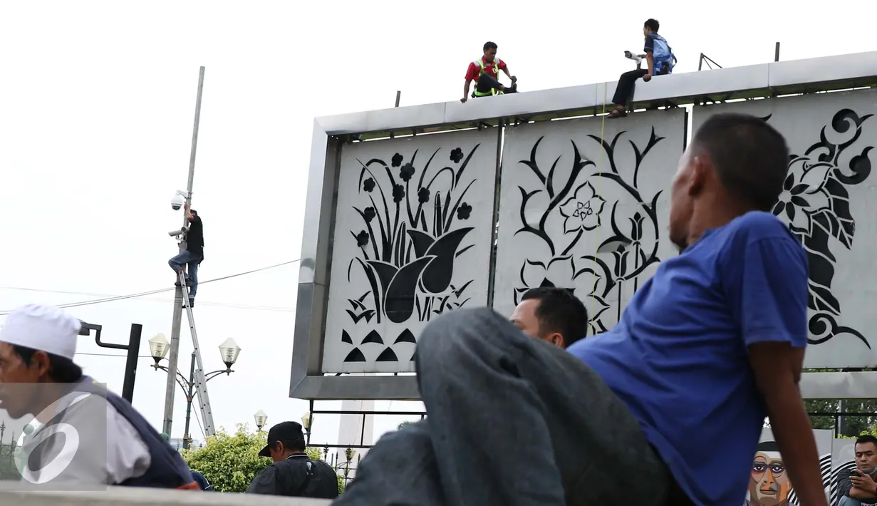 Pekerja memasang CCTV di Kawasan Monumen Nasional, Jakarta, Kamis (3/11). Pemasangan CCTV tersebut untuk meningkatkan keamanan di sekitar Monas. (Liputan6.com/Gempur M Surya)