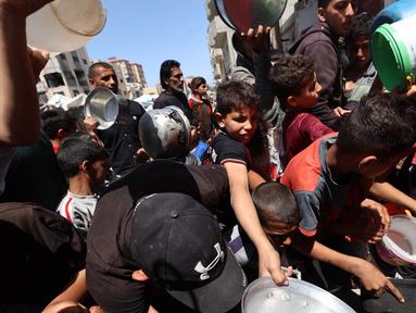 Warga Palestina mengantre untuk mendapatkan makanan dari dapur umum di kamp pengungsi Bureij, Jalur Gaza tengah pada 29 April 2025. (Eyad BABA/AFP)