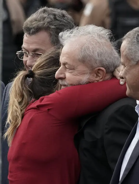 Mantan Presiden Brasil Luiz Inacio Lula da Silva dipeluk putrinya Lurian Cordeiro da Silva ketika ia keluar dari markas Polisi Federal di Curitiba, Brasil (8/11/2019). Lula adalah satu dari ribuan napi yang diuntungkan dari putusan tersebut. (AP Photo/Leo Correa)