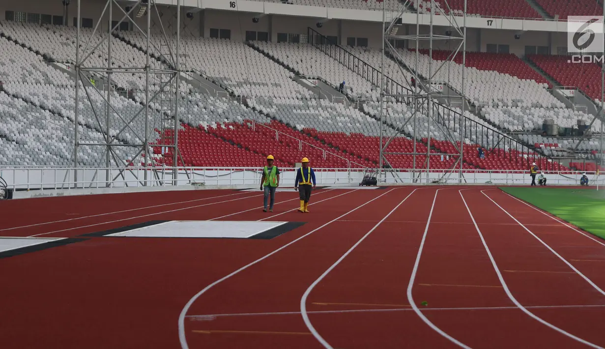 Pekerja berjalan di lintasan lari Stadion Utama Gelora Bung Karno, Jakarta, Kamis (23/11). Renovasi yang akan digunakan pada ajang Asian Games XVIII itu diperkirakan pada Februari 2018 sudah dapat digunakan untuk "test event". (Liputan6.com/Angga Yuniar)