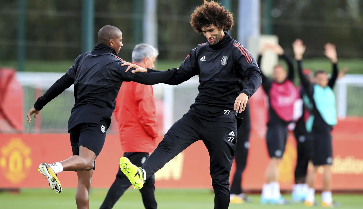 Pemain Manchester United, Marouane Fellaini (kanan) dan Ashley Young melakukan pemanasan di club training complex, Carrington, Manchester, (11/9/2017). MU akan melawan FC Basel di grup A. (Peter Byrne/PA via AP)