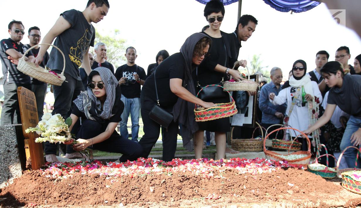 Eva Celia menaruh bunga di pemakaman neneknya, Nien Lesmana di TPU Tanah Kusir, Jakarta, Rabu (28/6). Ibu dari Indra Lesmana dan Mira Lesmana meninggal dunia pada usai 88 tahun. (Liputan6.com/Herman Zakharia)