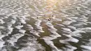 Pandangan udara menunjukkan para pria sedang memancing di tengah Laut Bothnia yang membeku di dekat Vaasa, Finlandia, 28 Desember 2018. Memancing di laut beku merupakan hal yang ditunggu-tunggu oleh sebagian warga setempat. (OLIVIER MORIN / AFP)