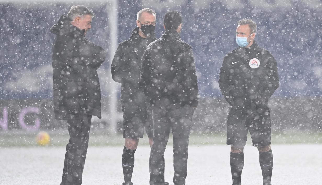 Wasit Martin Atkinson (kedua dari kiri) berbincang tentang turunnya salju dengan manajer tim Arsenal dan West Bromwich Albion menjelang laga lanjutan Liga Inggris 2020/21 pekan ke-17 di Hawthorns Stadium, Sabtu (2/1/2021). Arsenal menang 4-0 atas West Bromwich Albion. (AFP/Michael Regan/Pool)