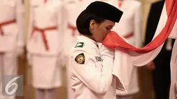 Anggota paskibraka 2016 mencium bendera merah putih saat Upacara Pengukuhan Paskibraka di Jakarta, Senin (15/8). Sebanyak 68 paskibraka dikukuhkan oleh Presiden yang telah melewati seleksi dari seluruh daerah di Indonesia. (Liputan6.com/Faizal Fanani)