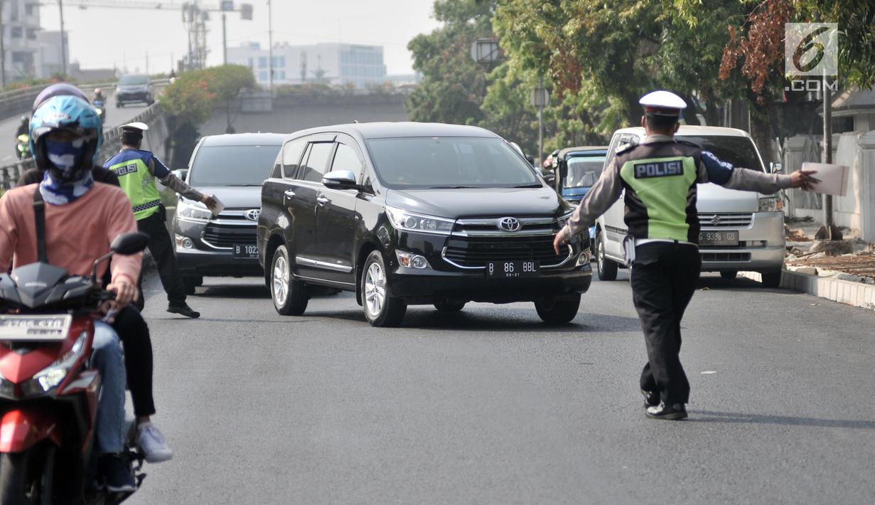 Polisi memberhentikan kendaraan saat hari pertama pemberlakuan perluasan sistem ganjil genap di Jalan Salemba Raya, Jakarta, Senin (9/9/2019). Polisi memberlakukan sanksi tilang terhadap pengendara yang melanggar aturan sistem ganjil genap. (merdeka.com/Iqbal Nugroho)