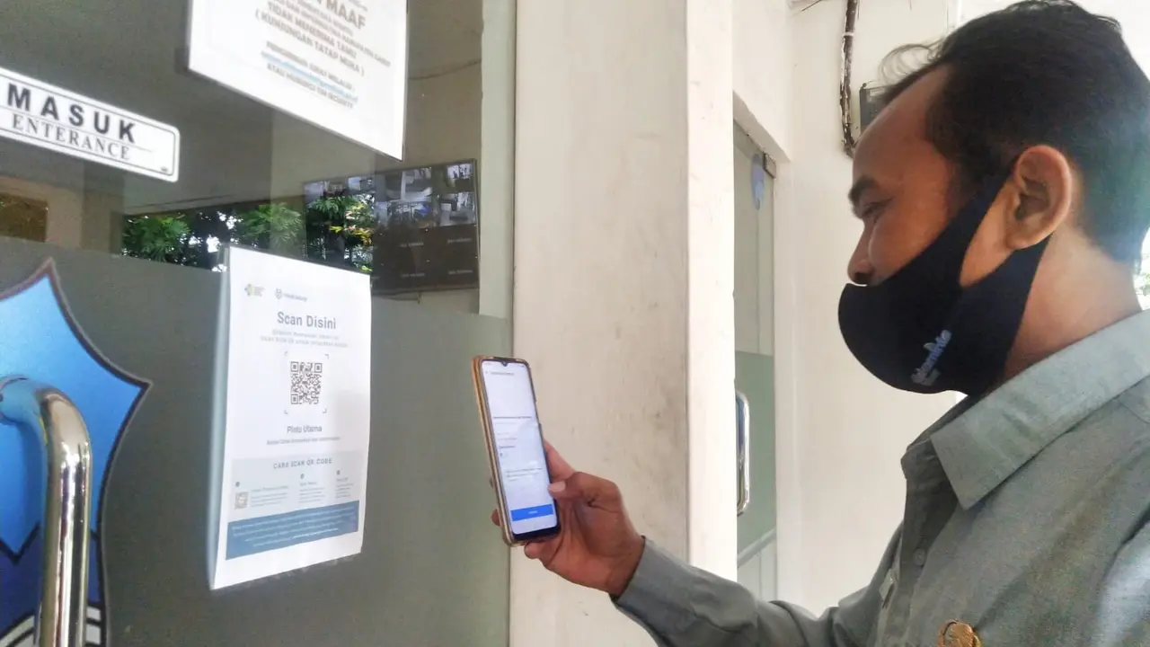 Salah seorang staf di lingkungan Sekterarit Daerah (Setda) Garut, Jawa Barat tengah menggunakan aplikasi Peduli Lindungi.