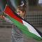 Seorang anak kecil mengibarkan bendera Palestina sebelum unjuk rasa pro-Palestina yang diikuti oleh ratusan orang, di pusat kota Bucharest, Rumania, Sabtu, 21 Oktober 2023. (AP Photo/Andreea Alexandru)