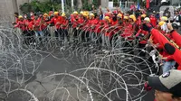 Pengunjuk rasa  menggelar demonstrasi di depan gedung DPR RI, Senayan, Jakarta, Selasa (14/3/2023). Unjuk rasa yang diikuti serikat buruh, mahasiswa, dan petani itu menuntut pemerintah untuk segera mencabut Peraturan Pemerintah Pengganti Undang-Undang (Perppu) Nomor 2 Tahun 2022 tentang Cipta Kerja. (Liputan6.com/Johan Tallo)