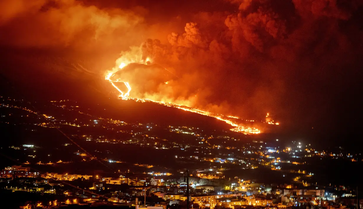 Lava mengalir saat gunung berapi terus meletus di pulau Canary La Palma, Spanyol (30/11/2021). Beberapa lubang vulkanik baru dibuka di La Palma, melepaskan lava baru yang mengalir cepat menuruni punggung bukit dan akan berdampak pada tanah, infrastruktur, dan rumah. (AP/Emilio Morenatti)