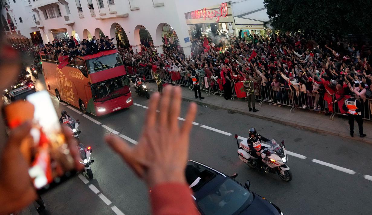 <p>Para pemain Timnas Maroko melakukan selebrasi di atas bus dan melambaikan tangan ke publik saat parade di Rabat , Maroko, 20 Desember 2022. Timnas Maroko mendapat sambutan hangat di negaranya setelah berhasil meraih juara keempat Piala Dunia 2022. (AP Photo/Mosa'ab Elshamy)</p>