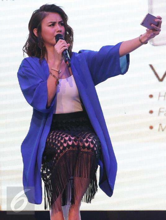 Product ambassador terbaru Vivo, Agnes Mo menjajal kamera smartphone pada peluncuran produk teranyar di Jakarta, Kamis (26/5/2016).  Produsen smartphone asal China itu meluncurkan dua smartphone, Vivo V3 Max dan Vivo V3. (Liputan6.com/Herman Zakharia)