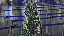 Pohon Natal yang dirakit dari barang-barang sitaan di Bandara Vilnius, Lithuania pada 12 Desember 2019. Bagian tubuh pohon Natal dibuat dengan menggunakan gunting yang dicat warna hijau agar terlihat seperti daun. . (Photo by Petras Malukas / AFP)