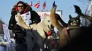 Aaron Burmeister dan timnya meninggalkan garis start Iditarod Sled Dog Race di Deshka Landing di Willow, Alaska, Minggu (7/3/2021). Tim anjing yang dipimpin oleh para pengemudi yang dikenal sebagai mushers berlari melintasi jalan-jalan bersalju. (Marc Lester/Anchorage Daily News via AP)