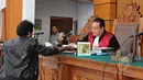 Ahli hukum tata negara Margarito memberikan berkas kepada hakim saat menjalani sidang sebagai saksi ahli dalam Sidang lanjutan praperadilan mantan Menteri ESDM, Jero Wacik di PN Jakarta Selatan, Jakarta, Rabu (22/4/2015).(Liputan6.com/Helmi Afandi)