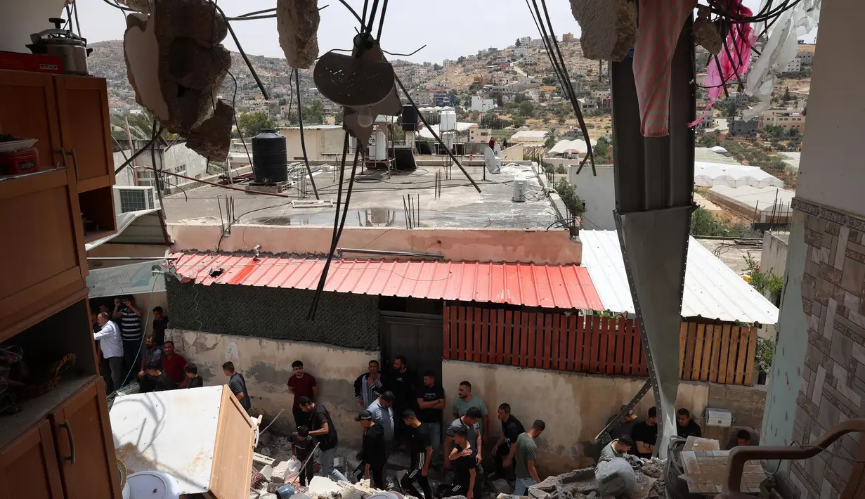 Warga Palestina memeriksa kerusakan di sekitar bangunan yang hancur setelah pasukan Israel mengepungnya di Tammun, Tepi Barat yang diduduki pada tanggal 15 Mei 2025. (Zain JAAFAR/AFP)