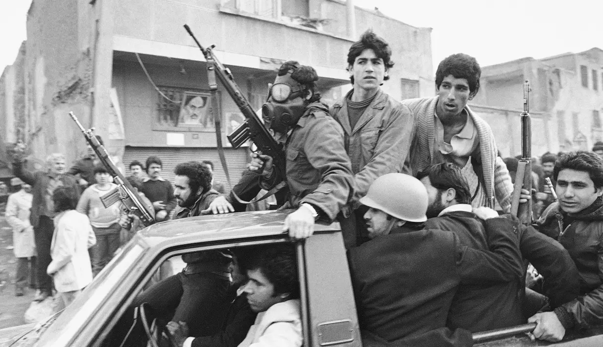 Kelompok bersenjata menaiki truk dekat markas besar Ayatollah Khomeini di Teheran, Iran, 12 Februari 1979. (AP Photo/Campion, File)