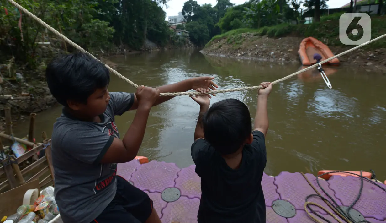 Anak-anak menggunakan perahu eretan di sungai Ciliwung, Jakarta, Selasa (3/11/2020). Perahu eretan di sungai Ciliwung masih bertahan sebagai penghubung Jakarta Timur dan Jakarta Selatan Selatan. (merdeka.com/Imam Buhori)