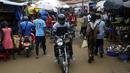 Orang-orang berbelanja di pasar Kaporo di Conakry, Guinea, Senin (13/9/2021). Pasukan elit militer Guinea melakukan kudeta dan menangkap Presiden Alpha Conde pada Minggu, 5 September lalu. (AP Photo/ Sunday Alamba)