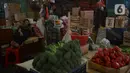 Seorang pedagang melihat ponselnya saat menunggu pembeli di di pasar Induk Kramat Jati, Jakarta, Rabu (7/4/2021).  Semua bahan pangan seperti cabai dan bawang akan stabil jelang puasa Ramadan dan Lebaran Idul Fitri 2021. (merdeka.com/Imam Buhori)