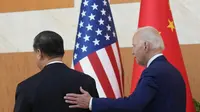 Presiden AS Joe Biden berjalan dengan Presiden China Xi Jinping sebelum pertemuan di sela-sela pertemuan puncak G20 di Nusa Dua, di Bali, Senin (14/11/2022). Pertemuan ini menjadi catatan sejarah di tengah panas dingin hubungan Amerika Serikat dan China. (AP/Alex Brandon)