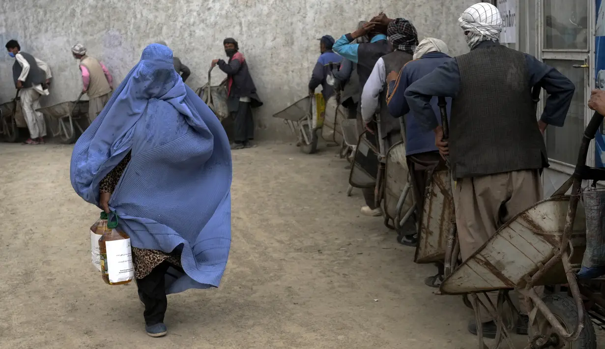 <p>Seorang perempuan Afghanistan menerima jatah makanan yang didistribusikan oleh kelompok bantuan kemanusiaan Korea Selatan, di Kabul, Selasa (10/5/2022). Taliban pada Sabtu pekan lalu memerintahkan semua perempuan Afghanistan menutupi seluruh tubuhnya atau mengenakan burqa tradisional di depan umum. (AP Photo/Ebrahim Noroozi)</p>