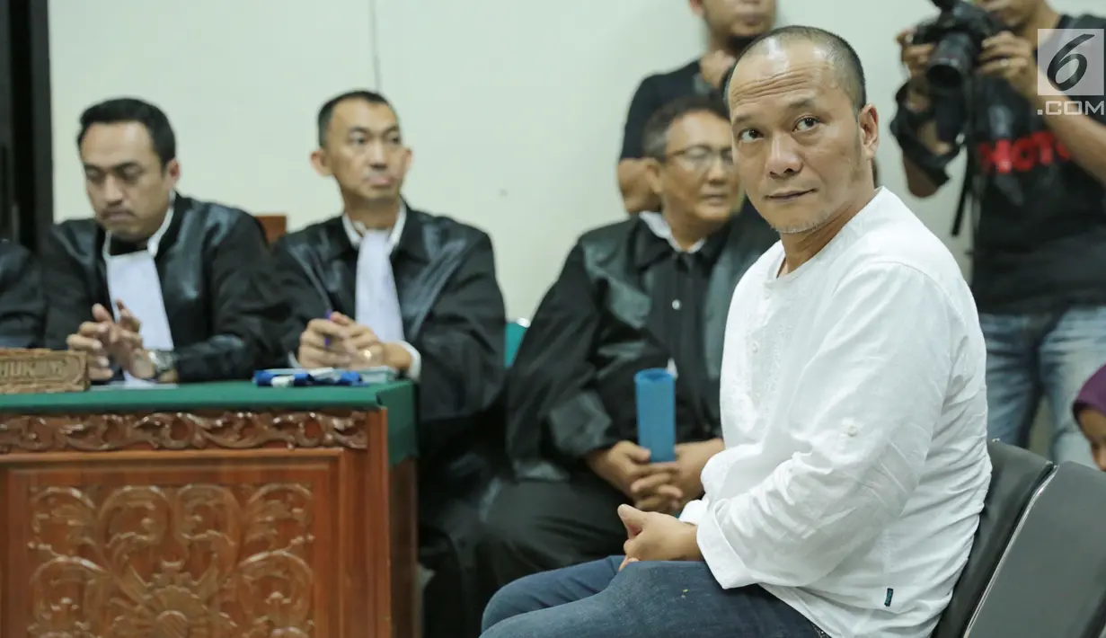 Rapper Iwa K duduk diruangan saat menjalani sidang perdana di Pengadilan Negeri Tangerang, Rabu (6/9). Pelantun 'Nombok Dong' tersebut terbukti membawa ganja seberat 1,485 gram dalam 3 linting rokok. (Liputan6.com/Pool)