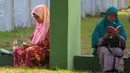 Warga Aceh berdoa di pemakaman massal Ulhee Lheue, Banda Aceh, Sabtu (26/12/2015).  Doa tersebut untuk keluarga mereka yang terkena bencana Tsunami pada 26 Desember 2014. (AFP Photo/ Chaideer Mahyuddin)