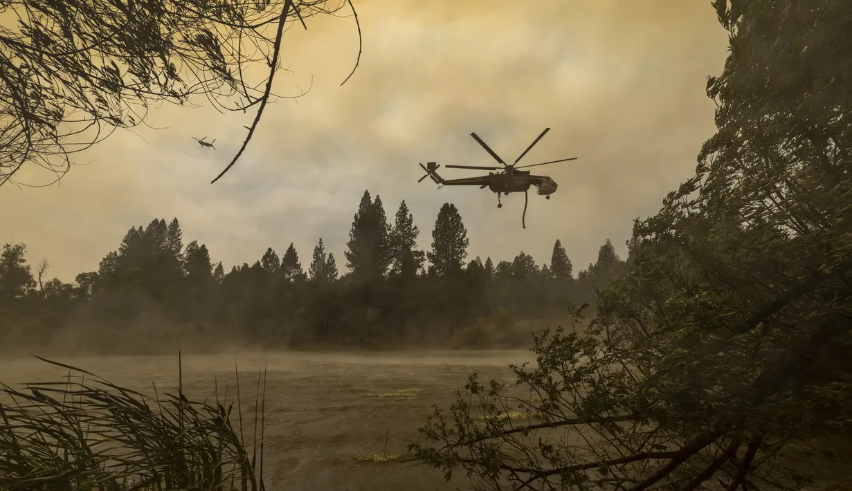 Helikopter Billings 4AJ mengisi ulang air untuk dijatuhkan ke Oak Fire dekat Mariposa, California, Amerika Serikat, 26 Juli 2022. Lebih dari seperempat kobaran api dekat Taman Nasional Yosemite telah berhasil dipadamkan. (DAVID MCNEW/AFP)
